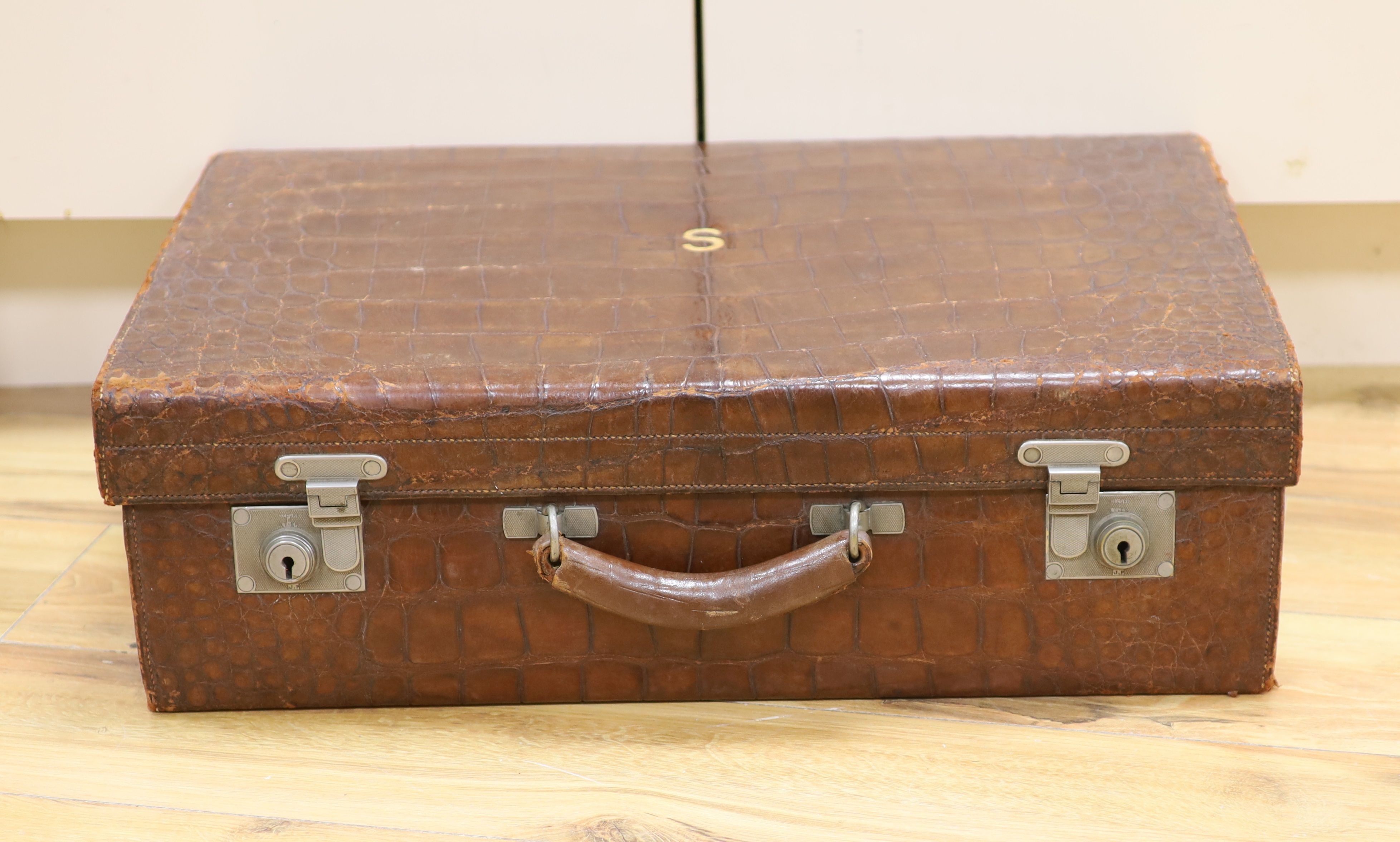 An early 20th century crocodile skin suitcase with blue leather lined interior 61cm